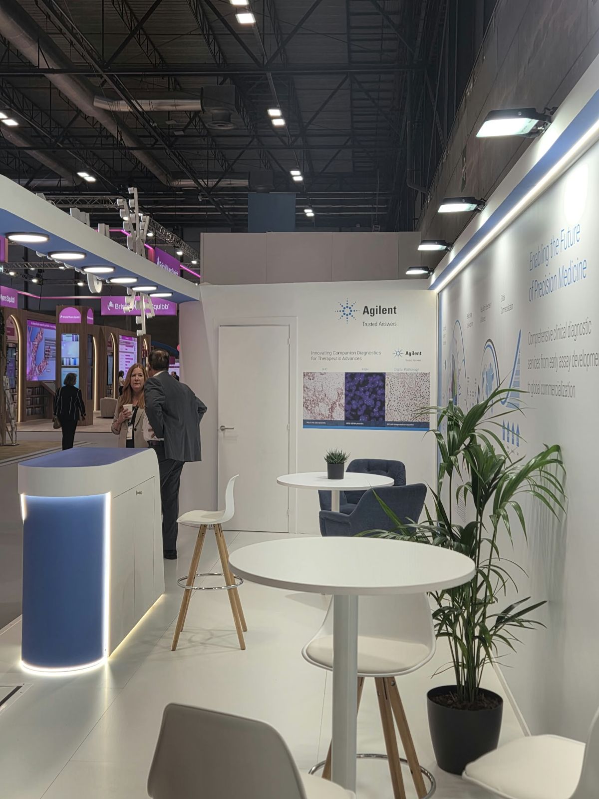Zona de reuniones informales con mesas altas en el stand de Agilent en ESMO 2026
